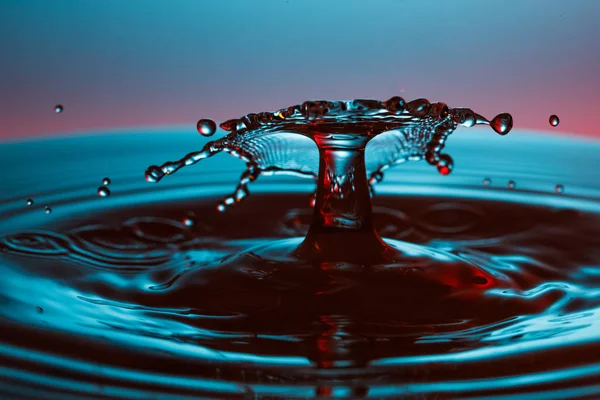 Droppe vatten faller ner i vattnet — Stockfoto