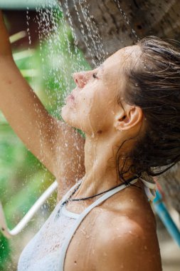 Güzel kız sahilde duş alır. 