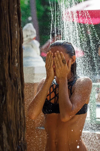 Gyönyörű lány vesz egy zuhany a strandon — Stock Fotó