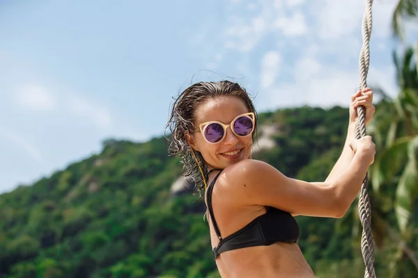 Piękna kobieta w czarnym stroju kąpielowym na huśtawce na plaży — Zdjęcie stockowe