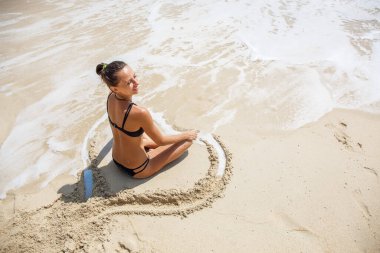 Plajda Lotus pozisyonunda güzel bir kız.