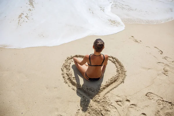 Mooi meisje in de Lotus positie op het strand — Stockfoto