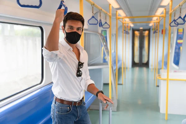 Coronavirus salgını sırasında metroda yüz maskesi takan yeni, normal, çekici beyaz bir adam iş gezisi sırasında yüz koruyucusu ve günlük beyaz gömlek giyen bir adam..