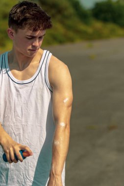 Genç Yetişkin erkek üzerinde güneş güneş krem dışında koyarak