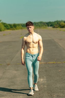 Genç Yetişkin erkek ileri yürüyüş gömleksiz sıcak bir yaz gününde
