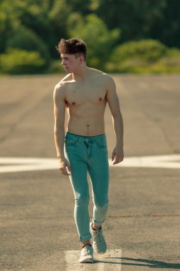 Genç Yetişkin erkek ileri yürüyüş gömleksiz sıcak bir yaz gününde