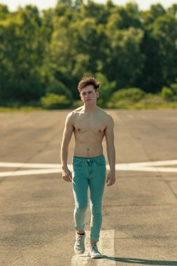 Genç Yetişkin erkek ileri yürüyüş gömleksiz sıcak bir yaz gününde
