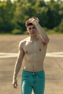 Genç Yetişkin erkek ileri yürüyüş bir el saçları ile sıcak bir yaz gününde çalışırken gömleksiz