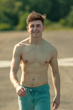 Genç Yetişkin erkek ileri yürüyüş gömleksiz sıcak bir yaz gününde