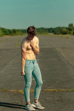 Sıcak bir yaz gününde kasların esneme Genç Yetişkin erkek