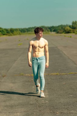 Genç Yetişkin erkek ileri yürüyüş gömleksiz sıcak bir yaz gününde