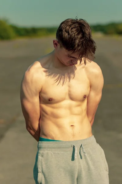 暖かい夏の日に外で上半身裸で立っている若い成人男性 — ストック写真