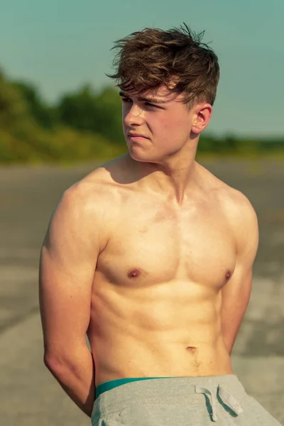 Sıcak bir yaz gününde gömleksiz dışında duran genç yetişkin erkek