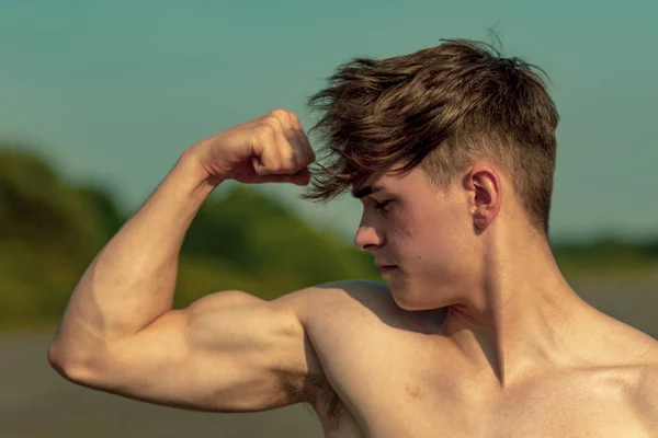 Sıcak bir yaz gününde gömleksiz pazı kas esneme Genç Yetişkin erkek