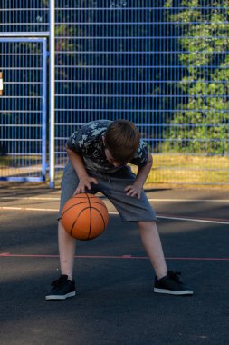 Pre-Teen Çocuk bir parkta bir basketbol oynamaktan