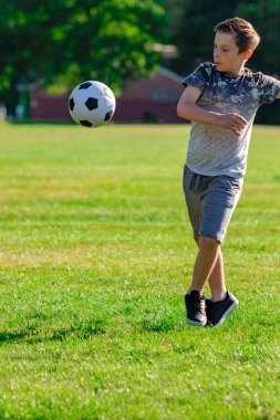 Pre-Teen Çocuk futbol bir parkta oynarken