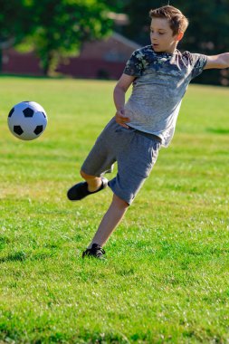 Pre-Teen Çocuk futbol bir parkta oynarken