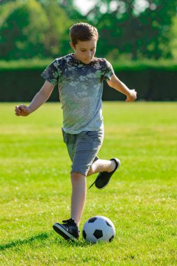 Pre-Teen Çocuk futbol bir parkta oynarken
