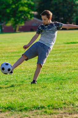 Pre-Teen Çocuk futbol bir parkta oynarken