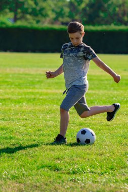 Pre-Teen Çocuk futbol bir parkta oynarken
