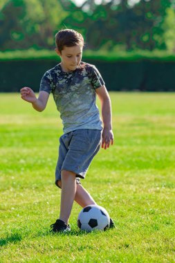 Pre-Teen Çocuk futbol bir parkta oynarken