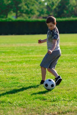 Pre-Teen Çocuk futbol bir parkta oynarken