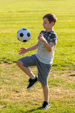 Pre-Teen Çocuk bir parkta futbol oynamaktan