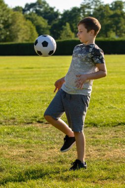 Pre-Teen Çocuk bir parkta futbol oynamaktan