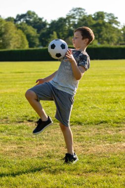 Pre-Teen Çocuk bir parkta futbol oynamaktan