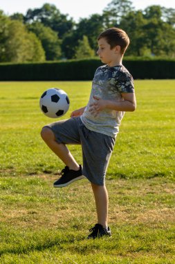 Pre-Teen Çocuk bir parkta futbol oynamaktan