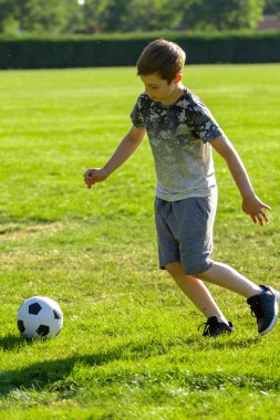 Pre-Teen Çocuk bir parkta futbol oynamaktan