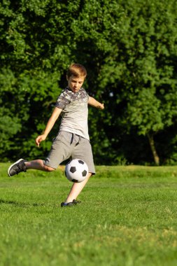 Pre-Teen Çocuk bir parkta futbol oynamaktan