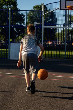 Pre-Teen Çocuk bir parkta bir basketbol oynamaktan