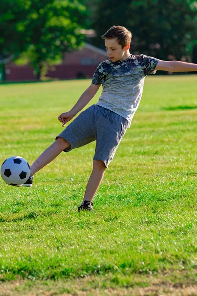 Pre-Teen Çocuk futbol bir parkta oynarken