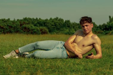 Gömleksiz genç erkek dult bir cep telefonunuzun ve sıcak bir yaz gününde