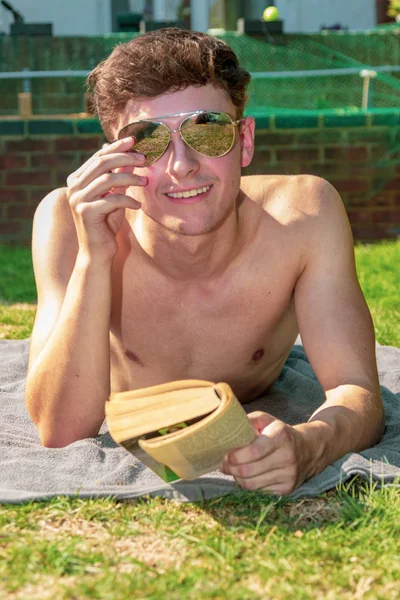 Jovem Adulto Sexo Masculino Deitado Sol Lendo Livro — Fotografia de Stock