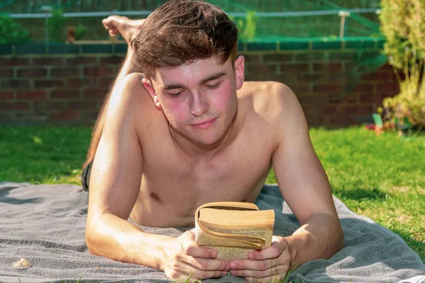 Jovem Adulto Sexo Masculino Deitado Sol Lendo Livro — Fotografia de Stock