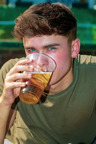 Genç Yetişkin dışında güneş zevk bir bira ile döşeme