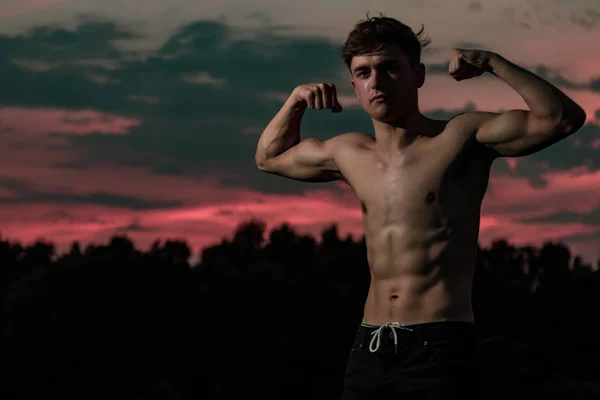 Jovem Adulto Masculino Flexionando Seus Músculos Braço Crepúsculo — Fotografia de Stock