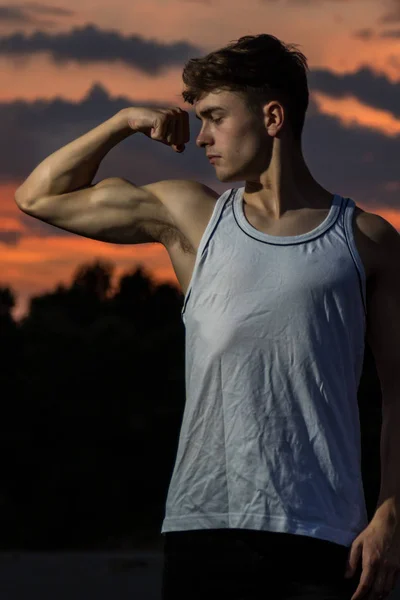 Jeune Homme Adulte Fléchissant Les Muscles Ses Bras Coucher Soleil — Photo