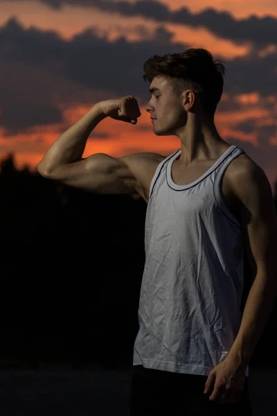 Jeune Homme Adulte Fléchissant Les Muscles Ses Bras Coucher Soleil — Photo