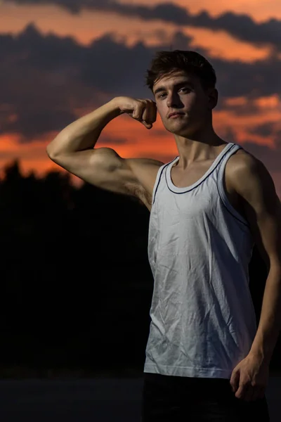 Junger Männlicher Erwachsener Lässt Bei Sonnenuntergang Seine Armmuskeln Spielen — Stockfoto