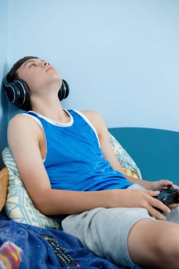 Genç çocuk onun yatakta iken, bilgisayar oyunu oynamak surat asıyorsun