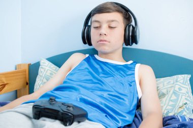 Onun yatakta iken, bilgisayar oyunu oynamak genci kaybetme