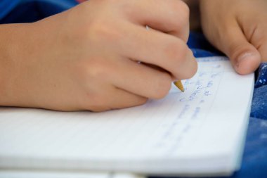 Ödev yapmak onun yatağında döşeme beyaz genç çocuk