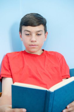 Beyaz genç çocuk yatağı üzerinde döşeme bir kitap okuma