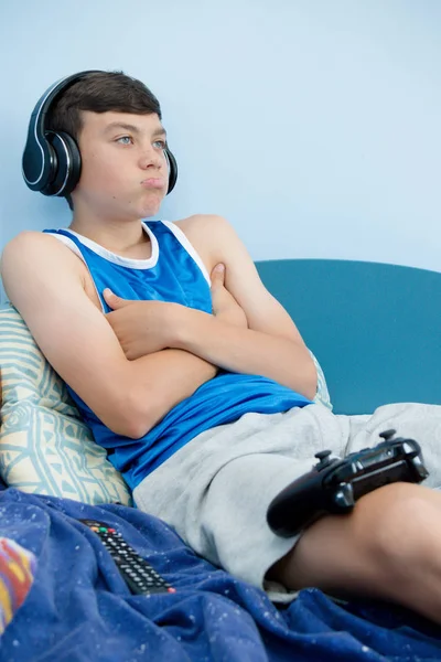 Genç çocuk onun yatakta iken, bilgisayar oyunu oynamak surat asıyorsun