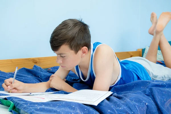 宿題をやって彼のベッドを置くこと白人の 代の少年 — ストック写真