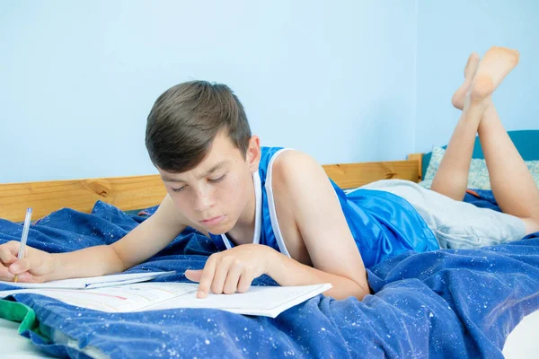 教科書を読んで彼のベッドを置くこと白人の 代の少年 — ストック写真
