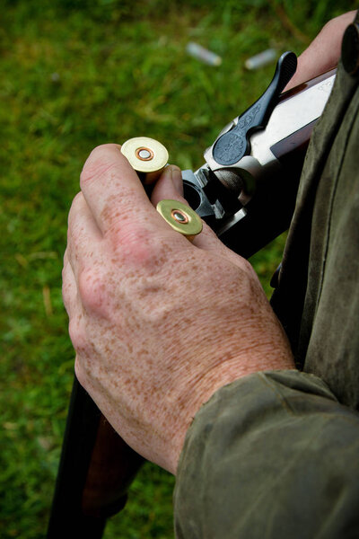 Загрузка двухствольного дробовика с новыми патронами
